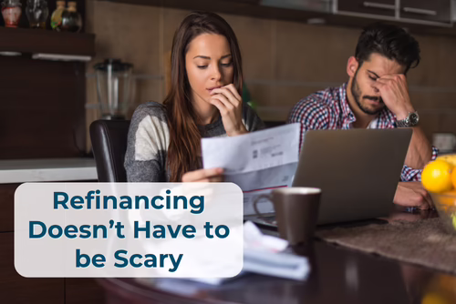 Couple reviewing bills and finances at a kitchen table, with the text “Refinancing Doesn’t Have to Be Scary.”