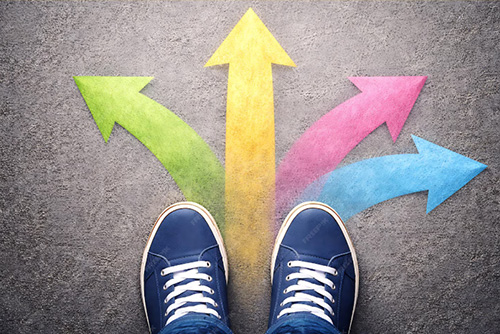 Four colored arrows point in different directions. A pair of blue sneakers is seen at the bottom edge of the photo
